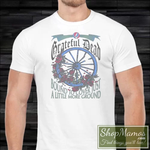 Grateful Dead 1994 The Wheel Summer Tour Bound To Cover Just A Little More Ground Men’s T Shirt – White Front View On Dark Wood Background Men's Grateful Dead 1994 The Wheel Summer Tour Bound To Cover Just A Little More Ground T Shirt In White, Front View On Dark Wood Background