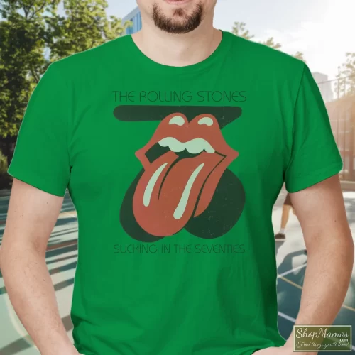 Rolling Stones Sucking In The Seventies Men’s T Shirt – Irish Green Front View On Light Wood Background Men's Rolling Stones Sucking In The Seventies T Shirt In Irish Green, Front View On Light Wood Background