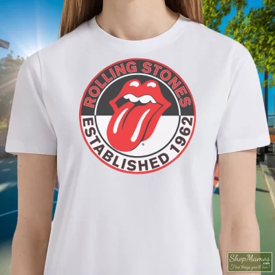 Women's The Rolling Stones White Est 1962 Tongue T Shirt In White, Front View On Dark Wood Background