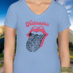 Leopard Tongue Rolling Stones Style Nebraska Huskers Shirt White 6 Women's Leopard Tongue Rolling Stones Style Nebraska Huskers White V Neck In Light Blue, Front View On Dark Wood Background
