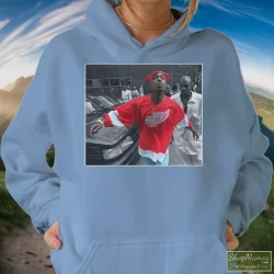 World Star Hiphop Tupac Shakur 2pac Detroit Spitting Hip Hop Rap Shirt 1 Women's World Star Hiphop Tupac Shakur 2pac Detroit Spitting Hip Hop Rap Hoodie In Light Blue, Front View On Dark Wood Background